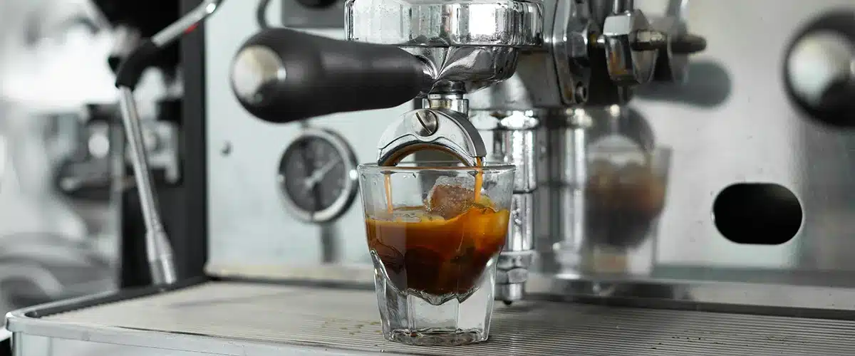 Espresso lopend onder een espressomachine met ijsblokjes