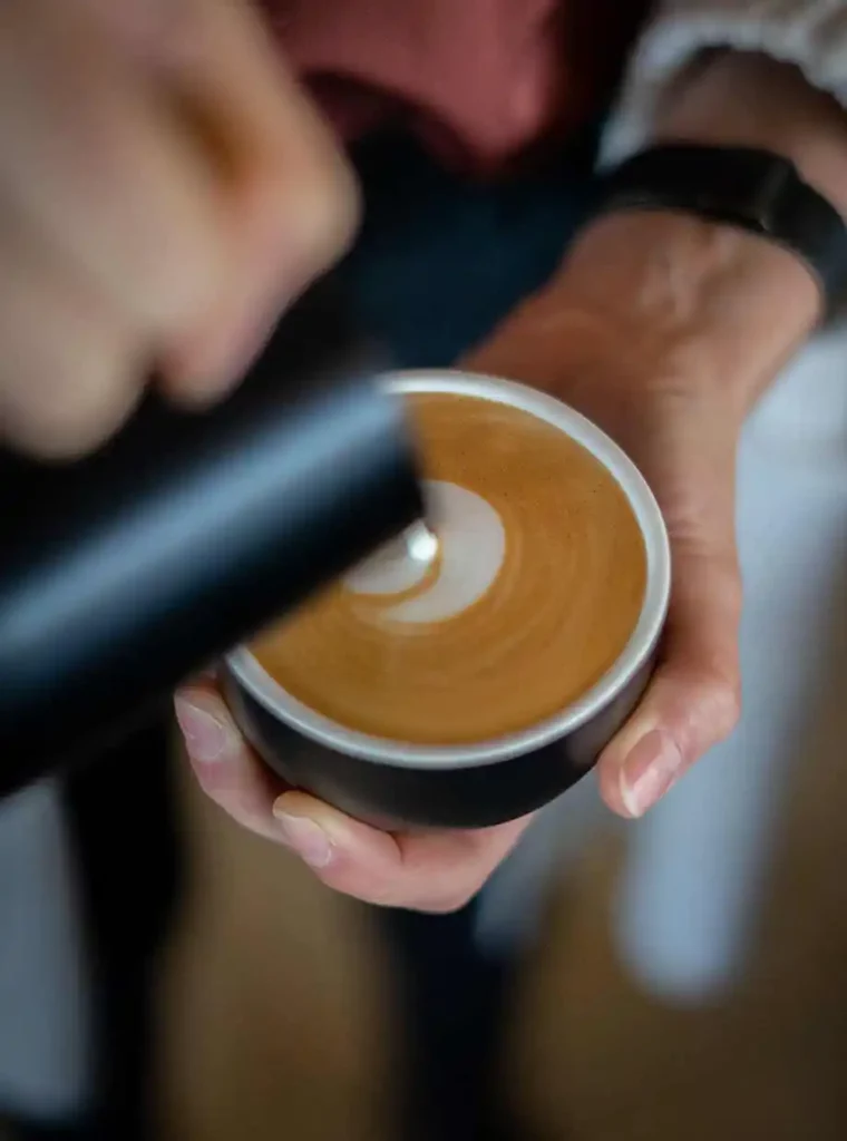Cappuccino waarbij de latte art geschonken word