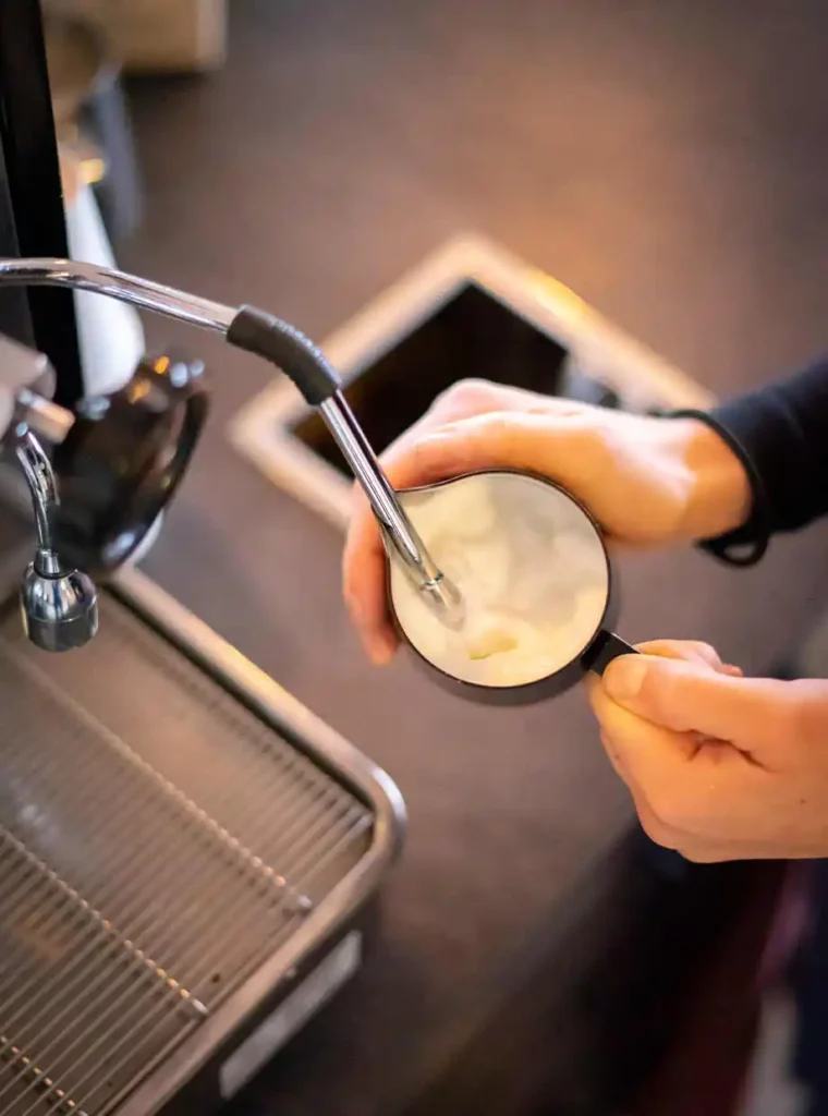 Melk die opgeschuimd word voor een cappuccino